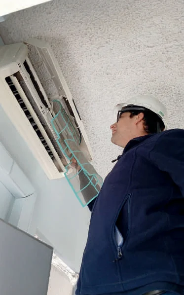 Técnico de Contraclima revisando un equipo de aire acondicionado split muro